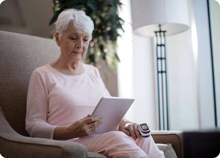 Masimo - Woman sitting on chair looking at ipad